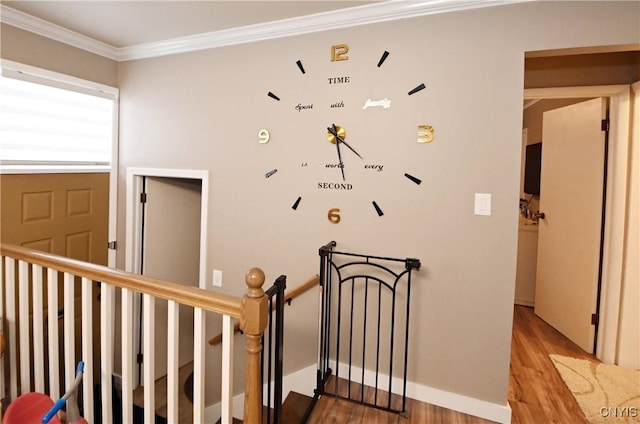 stairs featuring crown molding and hardwood / wood-style flooring