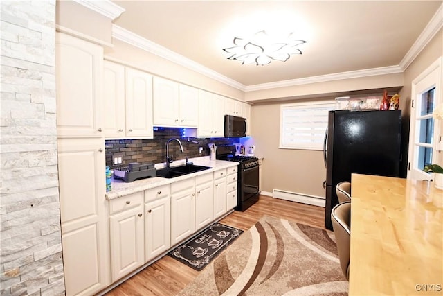 kitchen featuring white cabinetry, a baseboard radiator, sink, ornamental molding, and black appliances