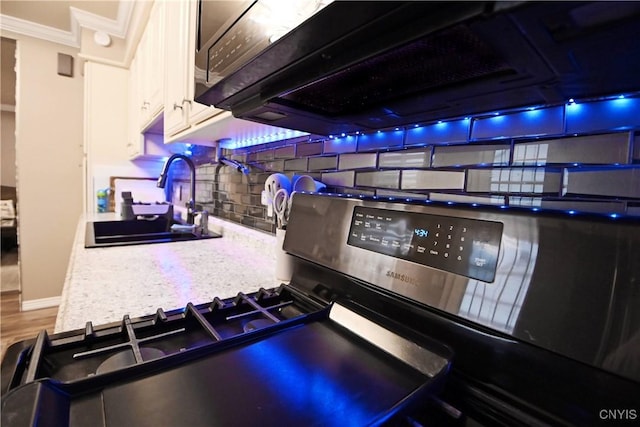 kitchen with sink, decorative backsplash, and stainless steel range with gas cooktop