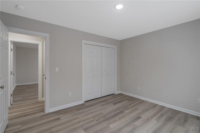 unfurnished bedroom featuring light hardwood / wood-style floors and a closet