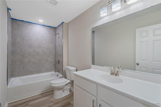 full bathroom with hardwood / wood-style flooring, vanity, toilet, and tiled shower / bath combo