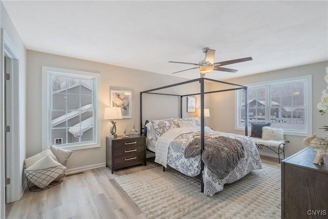 bedroom featuring multiple windows, light hardwood / wood-style flooring, and ceiling fan