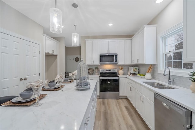 kitchen with appliances with stainless steel finishes, sink, and white cabinets