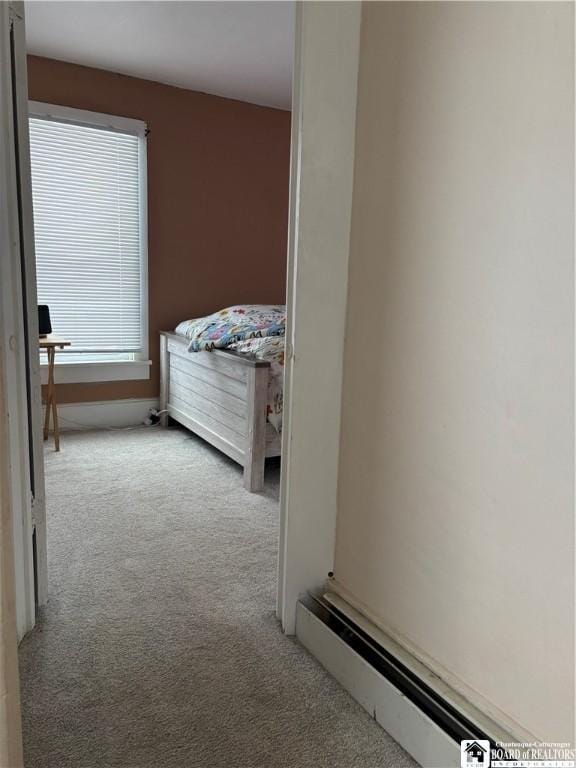 hallway with a baseboard radiator and light colored carpet