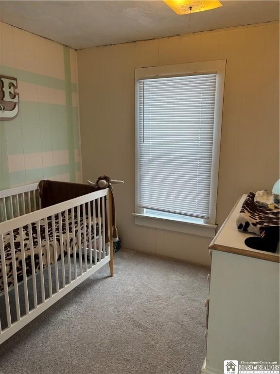 bedroom with carpet floors and a crib