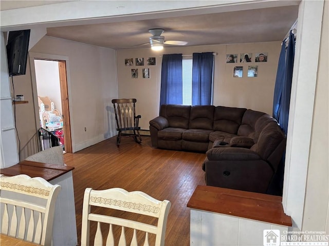 living room featuring wood-type flooring and ceiling fan