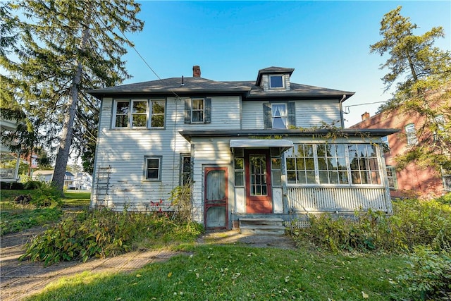 view of front of house with a sunroom and a front yard