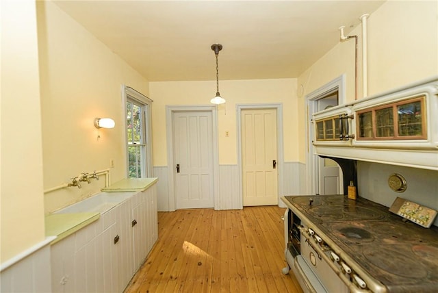 kitchen featuring pendant lighting, white cabinetry, and light wood-type flooring