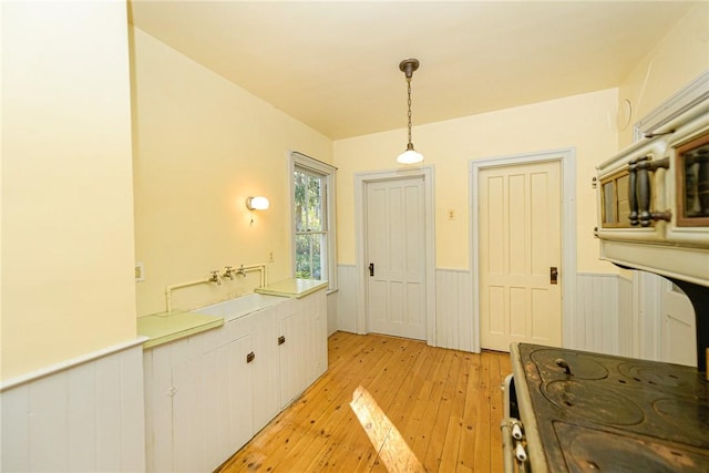 kitchen featuring pendant lighting, light hardwood / wood-style flooring, and white cabinets