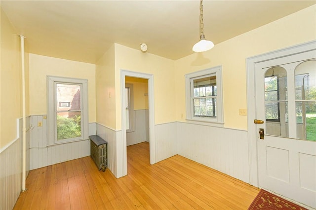 foyer entrance featuring radiator heating unit and hardwood / wood-style floors