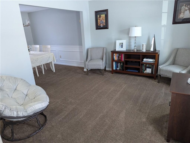 sitting room featuring dark carpet