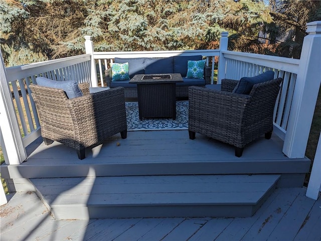 deck featuring an outdoor living space with a fire pit