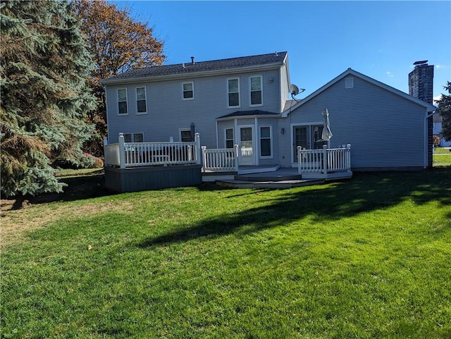 back of house featuring a lawn and a deck