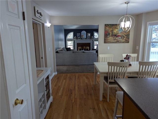 dining room with a fireplace, dark hardwood / wood-style floors, and a chandelier