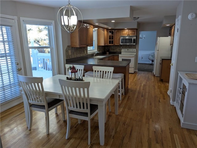 dining area with wood-type flooring, sink, and a chandelier