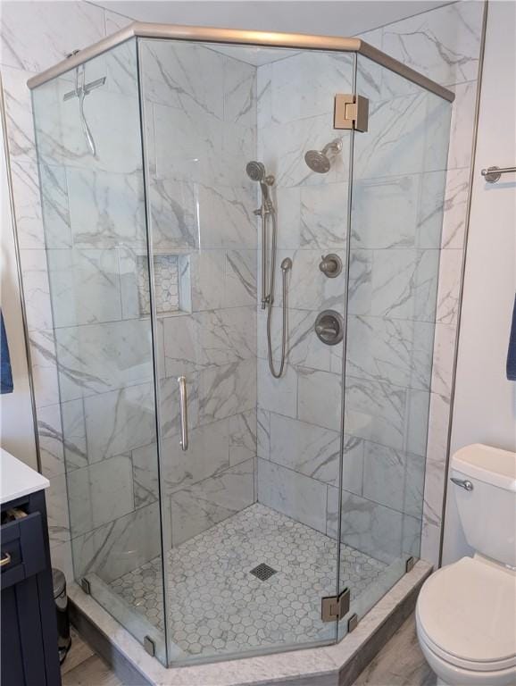 bathroom featuring walk in shower, vanity, and toilet