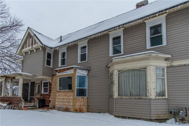 view of snow covered back of property