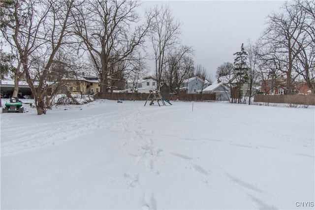 yard covered in snow with a playground