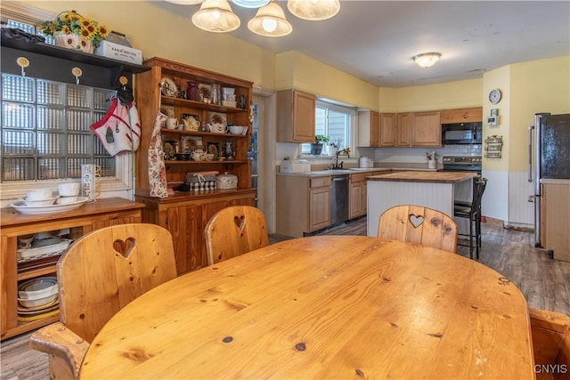 kitchen featuring hardwood / wood-style flooring, appliances with stainless steel finishes, a center island, and sink