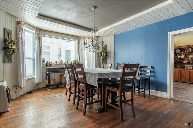 dining area with wood-type flooring and an inviting chandelier