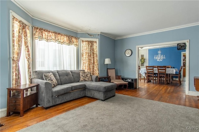 living room featuring crown molding, wood-type flooring, and a notable chandelier