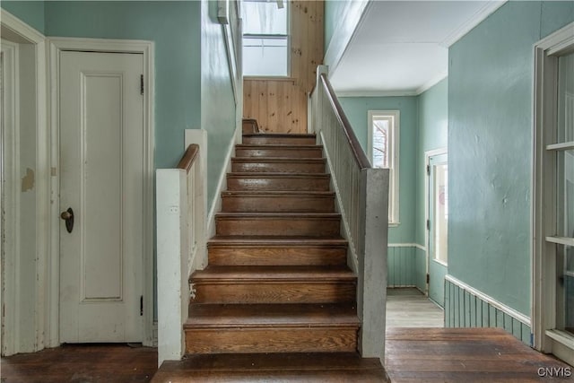 staircase featuring ornamental molding and wood-type flooring