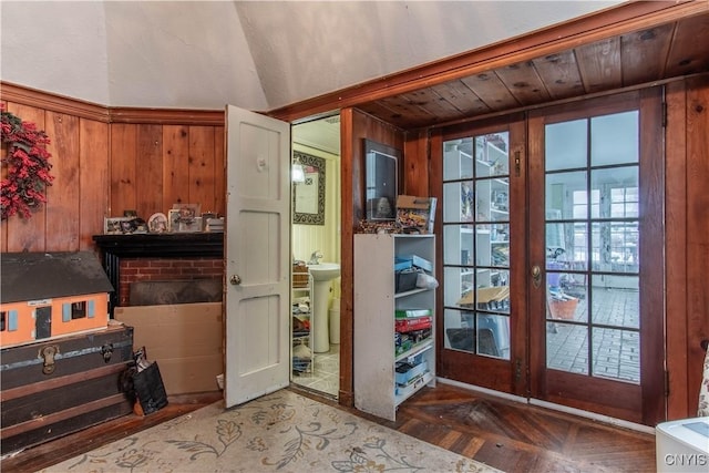 doorway featuring sink, dark parquet floors, and wood walls