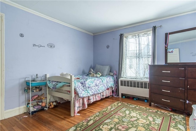 bedroom featuring crown molding, radiator heating unit, and hardwood / wood-style flooring