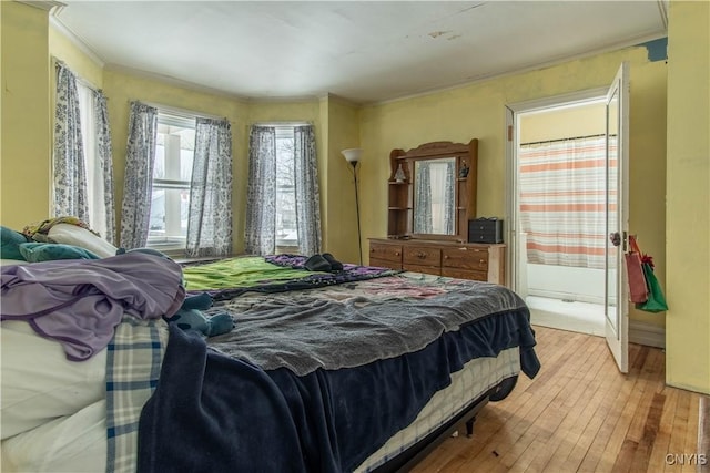 bedroom with crown molding and light hardwood / wood-style flooring