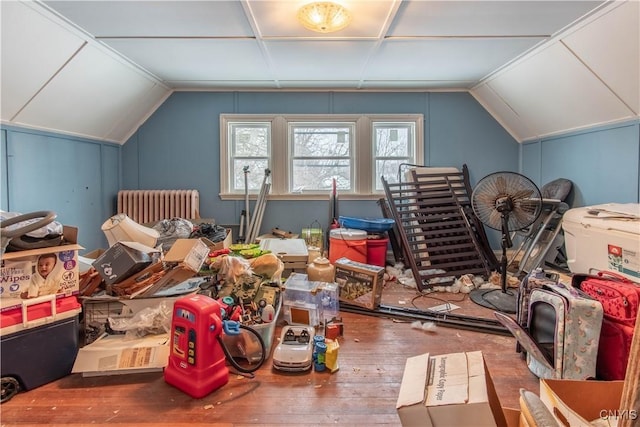 additional living space with radiator heating unit, wood-type flooring, and vaulted ceiling