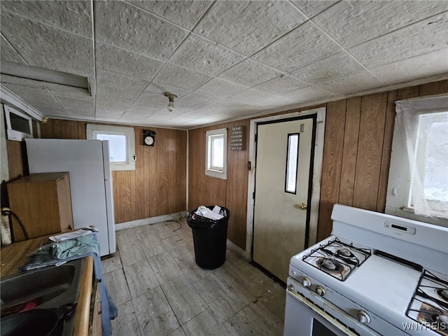 kitchen featuring white appliances and wooden walls