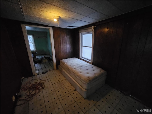 bedroom featuring wood walls