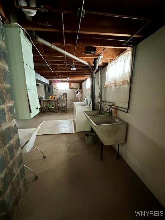 basement featuring washing machine and clothes dryer and sink