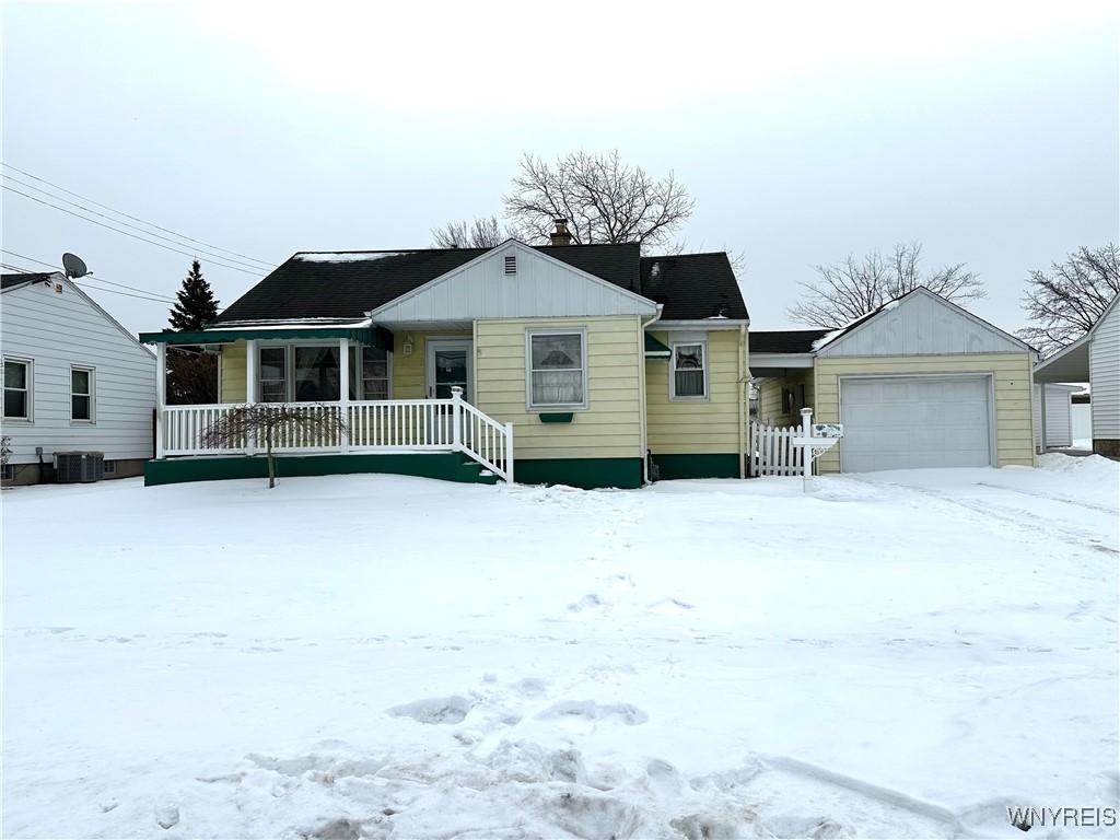 view of front of property with central AC, a garage, and covered porch