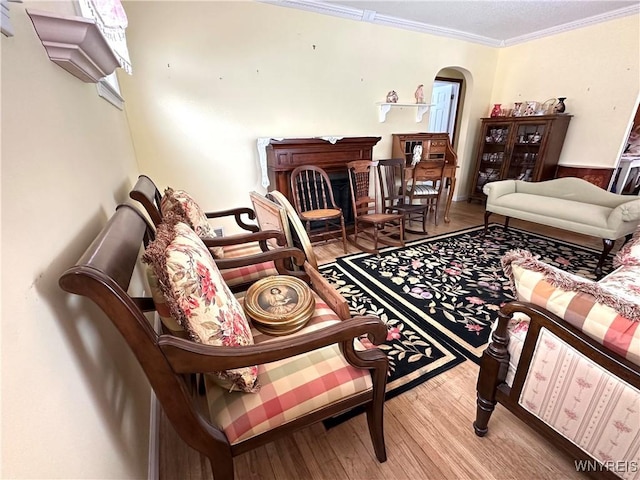 sitting room featuring ornamental molding and wood-type flooring