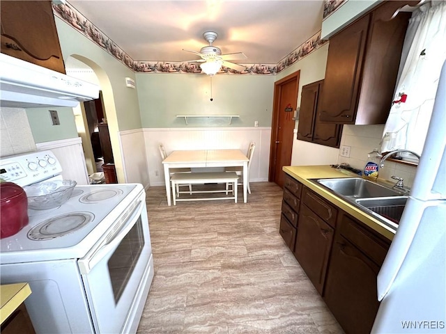 kitchen featuring white range with electric cooktop, dark brown cabinetry, sink, tasteful backsplash, and ceiling fan