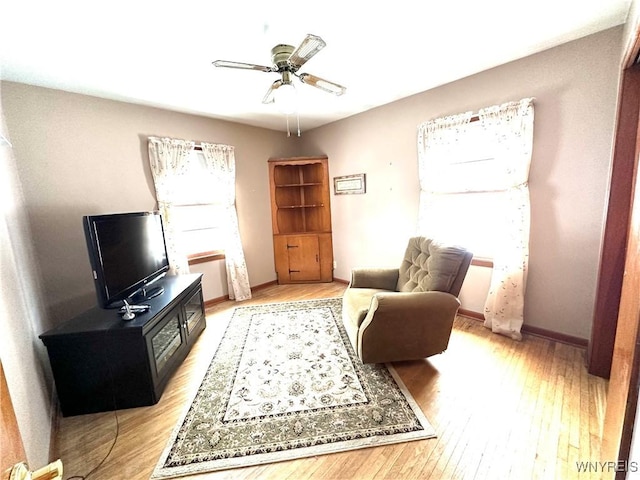 living area with ceiling fan and light wood-type flooring