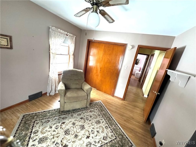 living area with ceiling fan and light wood-type flooring