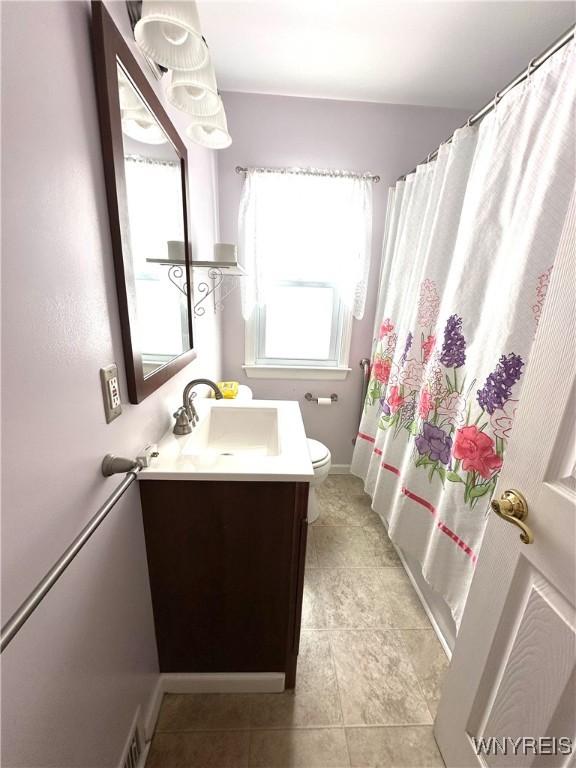 bathroom with tile patterned flooring, vanity, a shower with curtain, and toilet