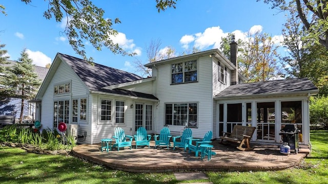 back of house featuring a sunroom, a yard, and a patio