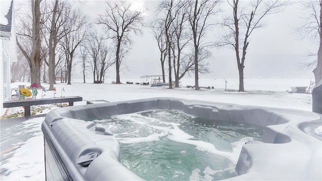 snow covered deck with a hot tub