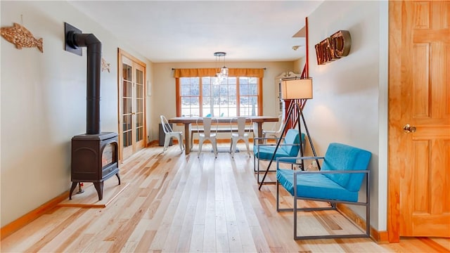 dining space featuring light hardwood / wood-style flooring and a wood stove