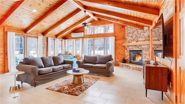 living room with a stone fireplace, a wall mounted AC, beam ceiling, and wood walls