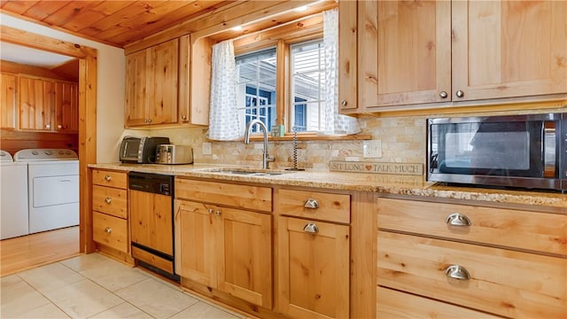 kitchen with sink, light tile patterned floors, paneled dishwasher, separate washer and dryer, and decorative backsplash