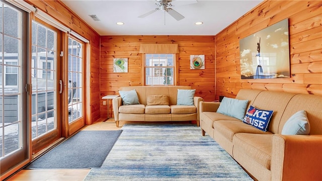 living room with french doors, hardwood / wood-style flooring, and wood walls