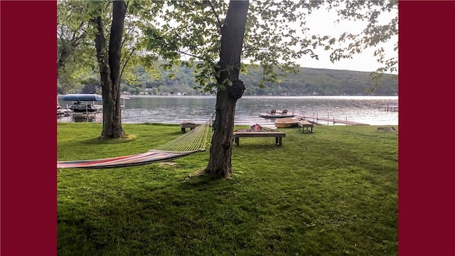 surrounding community featuring a water view and a yard