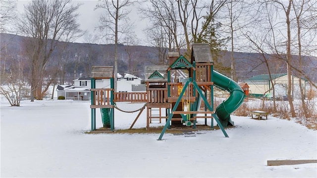 snow covered playground featuring a mountain view