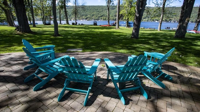 view of property's community featuring a water view, a yard, and a patio