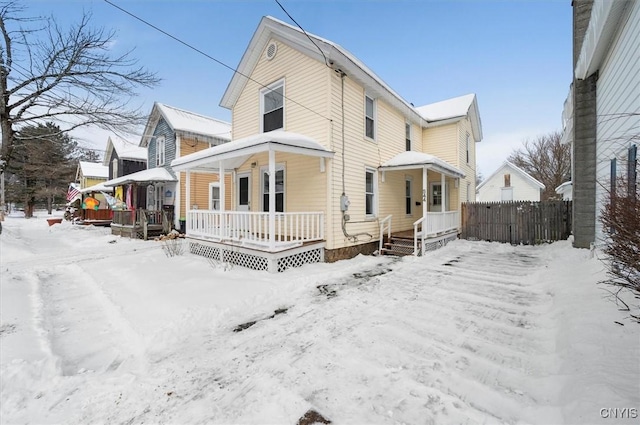 snow covered property featuring covered porch