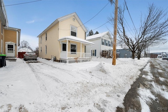 snow covered property featuring a porch